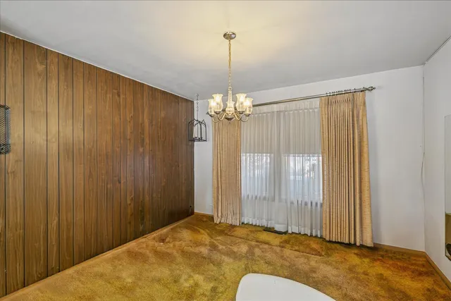 a view of a livingroom with chandelier closet and windows