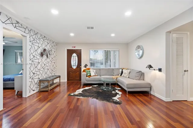 a living room with furniture and wooden floor