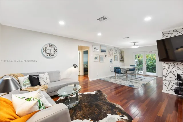 a living room with furniture and wooden floor