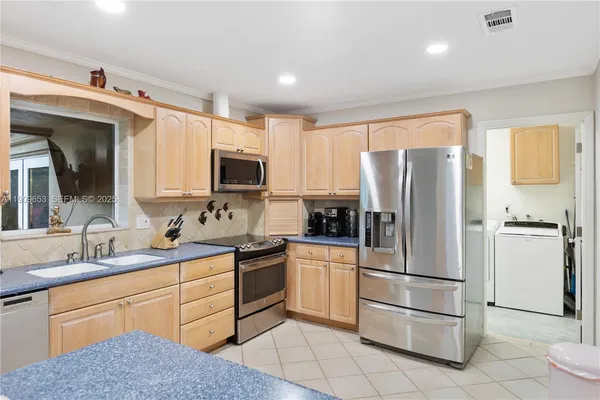 a kitchen with white cabinets and appliances