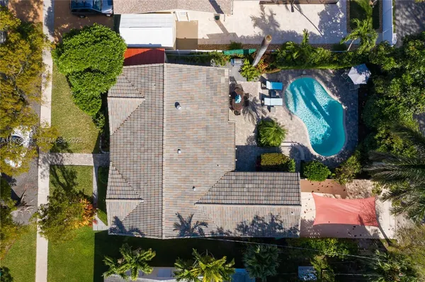 an aerial view of a house with a yard and large trees