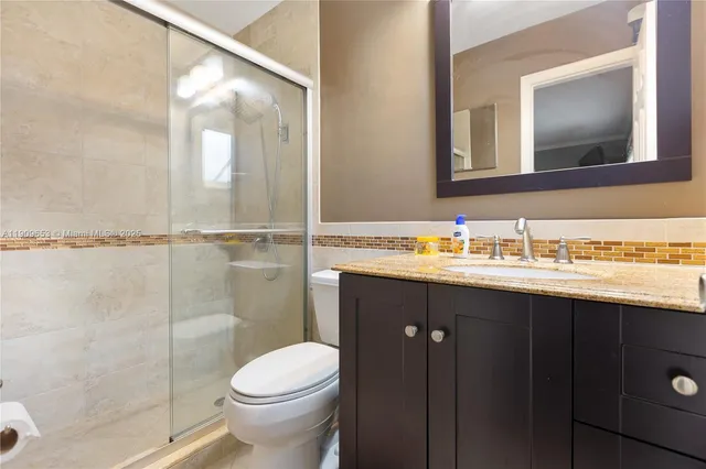 a bathroom with a sink vanity mirror and toilet