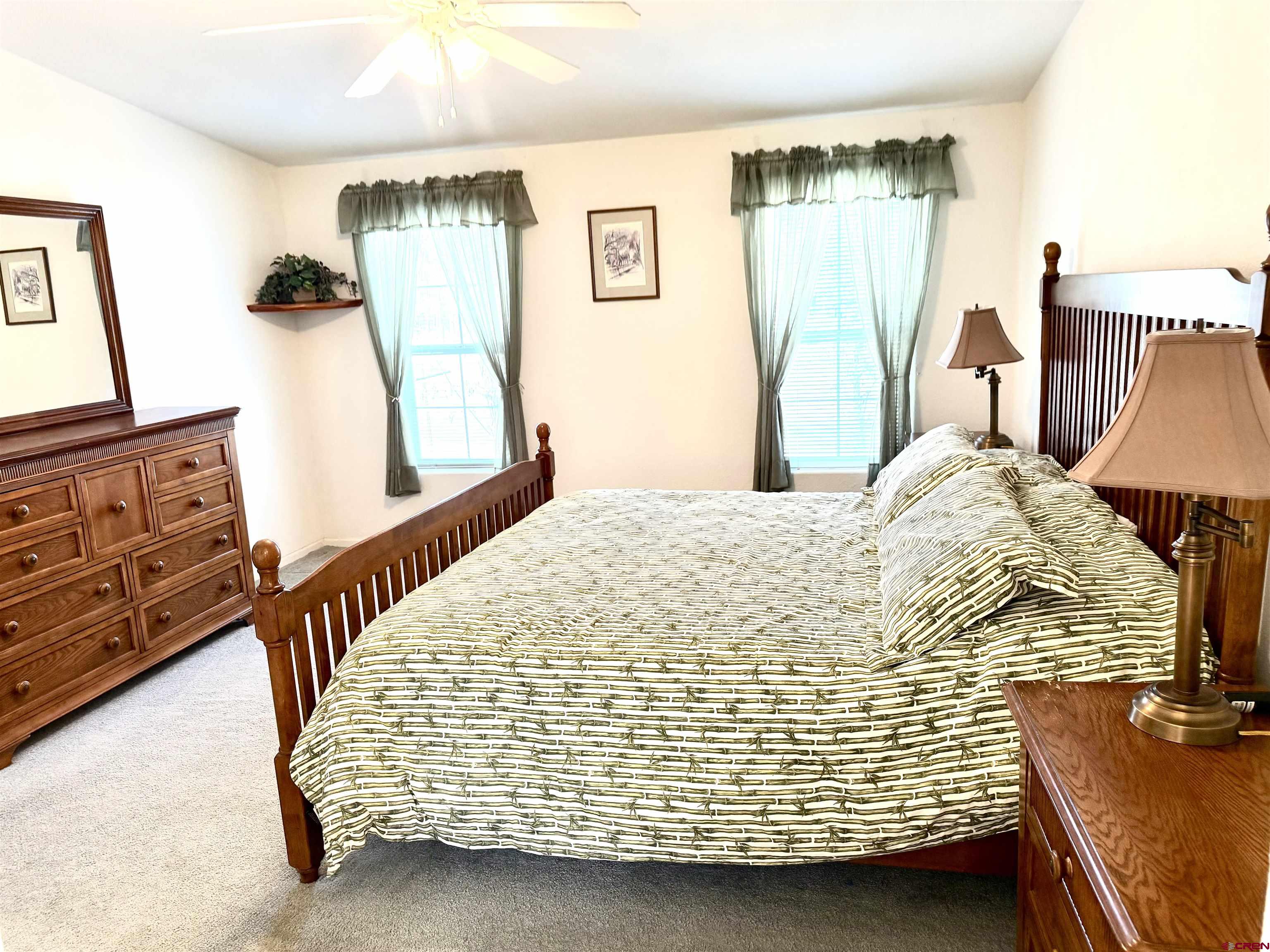 901 6530 Road, Unit 1101 Montrose, CO 81401 - Photo 18 of 45 a bedroom with a bed and a flat tv screen on the dresser