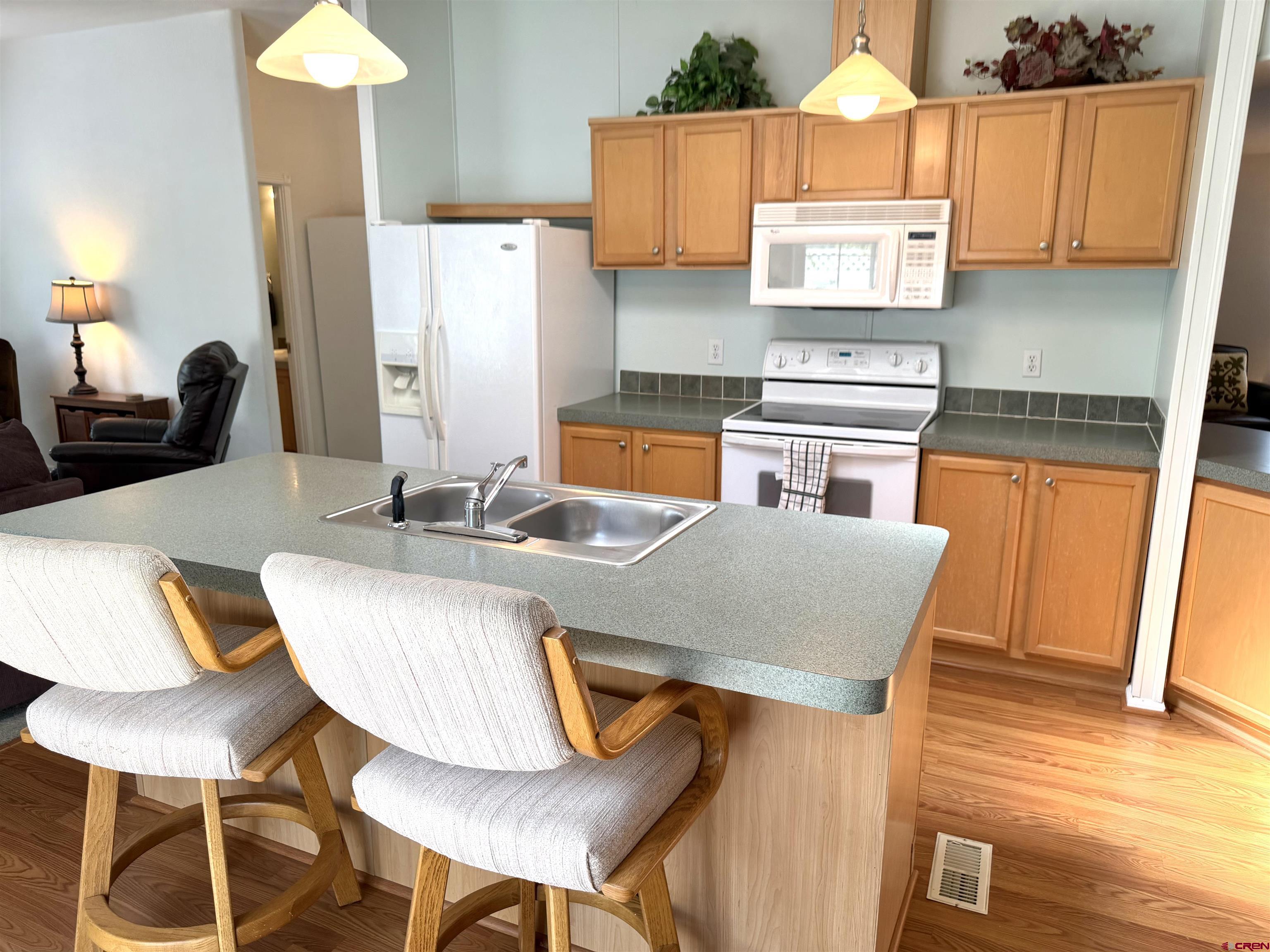 901 6530 Road, Unit 1101 Montrose, CO 81401 - Photo 31 of 45 a kitchen with stainless steel appliances granite countertop a table chairs and a refrigerator