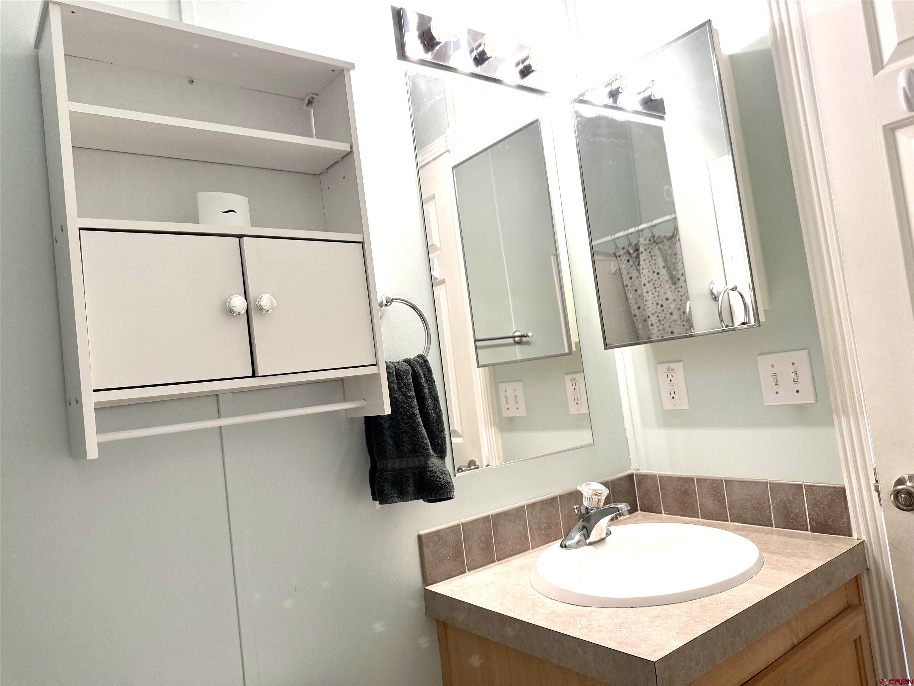 901 6530 Road, Unit 1101 Montrose, CO 81401 - Photo 34 of 45 a bathroom with a sink and mirror with bathtub