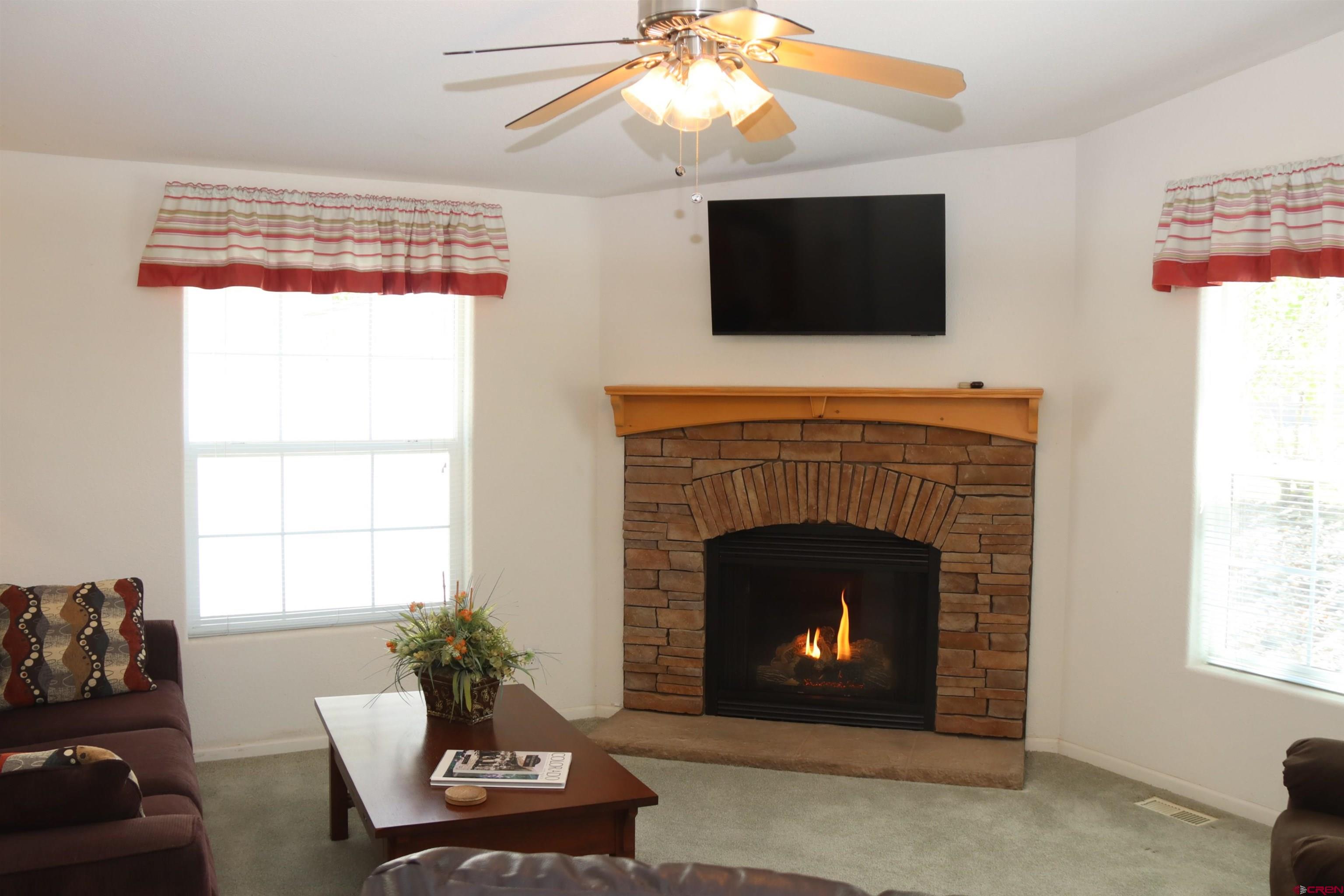 901 6530 Road, Unit 1101 Montrose, CO 81401 - Photo 38 of 45 a living room with furniture a flat screen tv and a fireplace