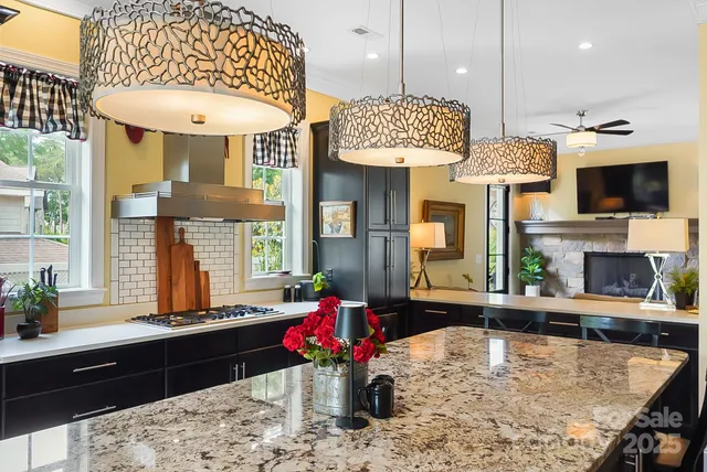 a kitchen with a refrigerator a stove and a dining table with wooden floor