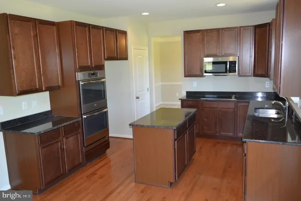 a kitchen with granite countertop wooden cabinets and stainless steel appliances
