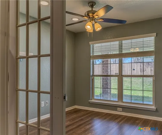 a view of a livingroom with a large window and wooden floor