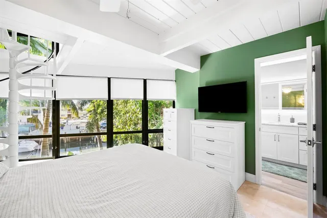 a bedroom with a bed tv and window