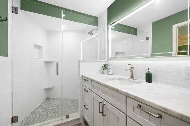 a bathroom with a shower sink and mirror