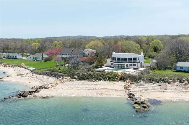 an aerial view of a house with a yard and lake view