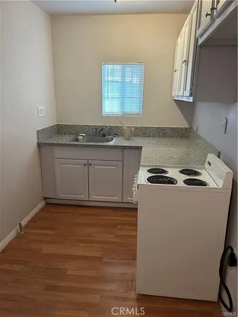 a kitchen with granite countertop a sink and a stove