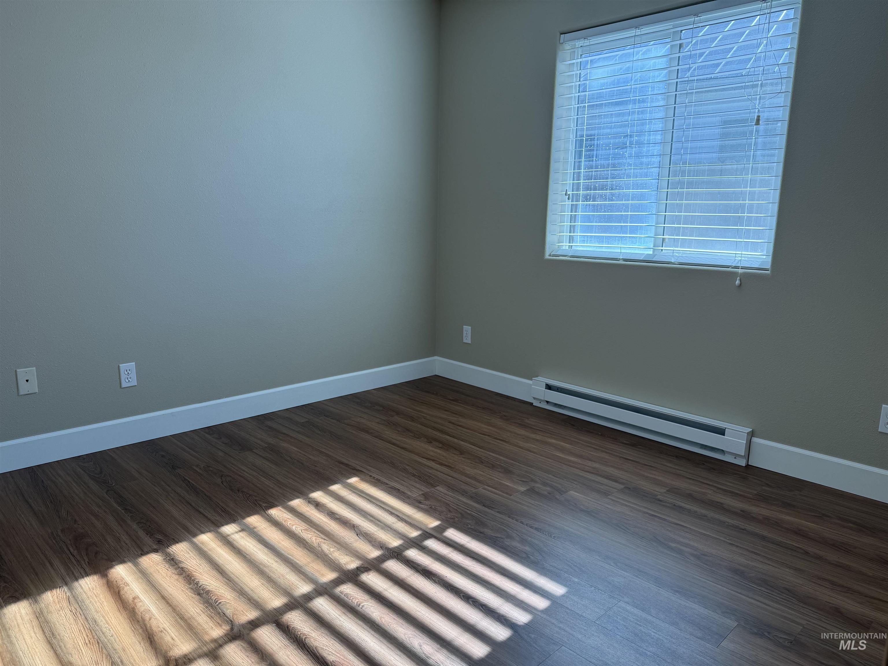 257 Pintail Lane Moscow, ID 83843 - Photo 10 of 28 Unfurnished room with baseboard heating and dark wood-style flooring