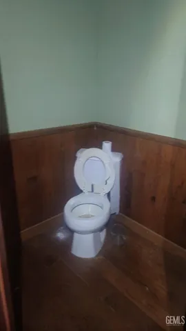 a toilet sitting in a bathroom next to a wooden wall