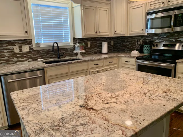 a kitchen with granite countertop stainless steel appliances and cabinets