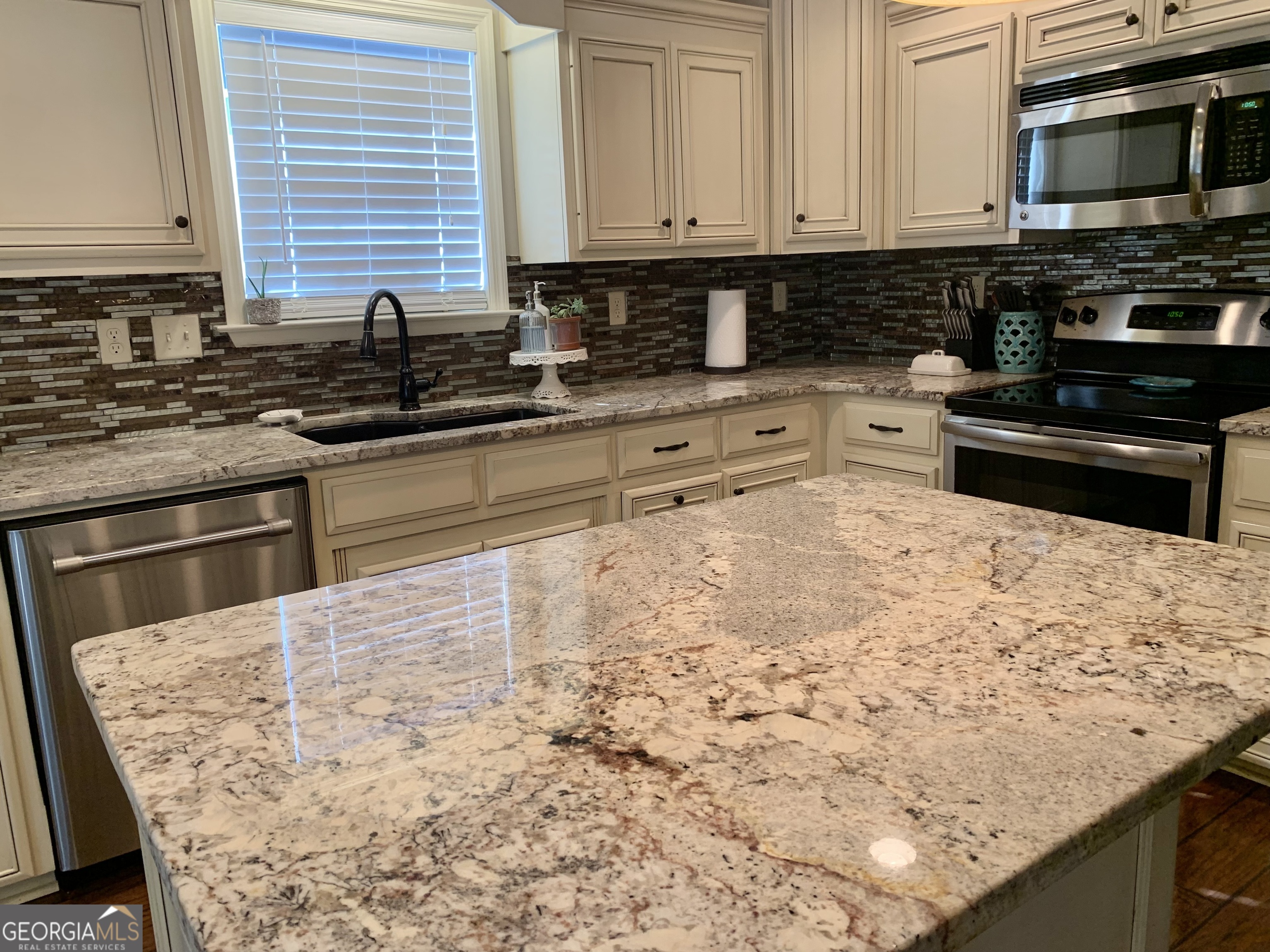 4192 Bright Creek Road Hahira, GA 31632 - Photo 12 of 28 a kitchen with granite countertop white cabinets and stainless steel appliances