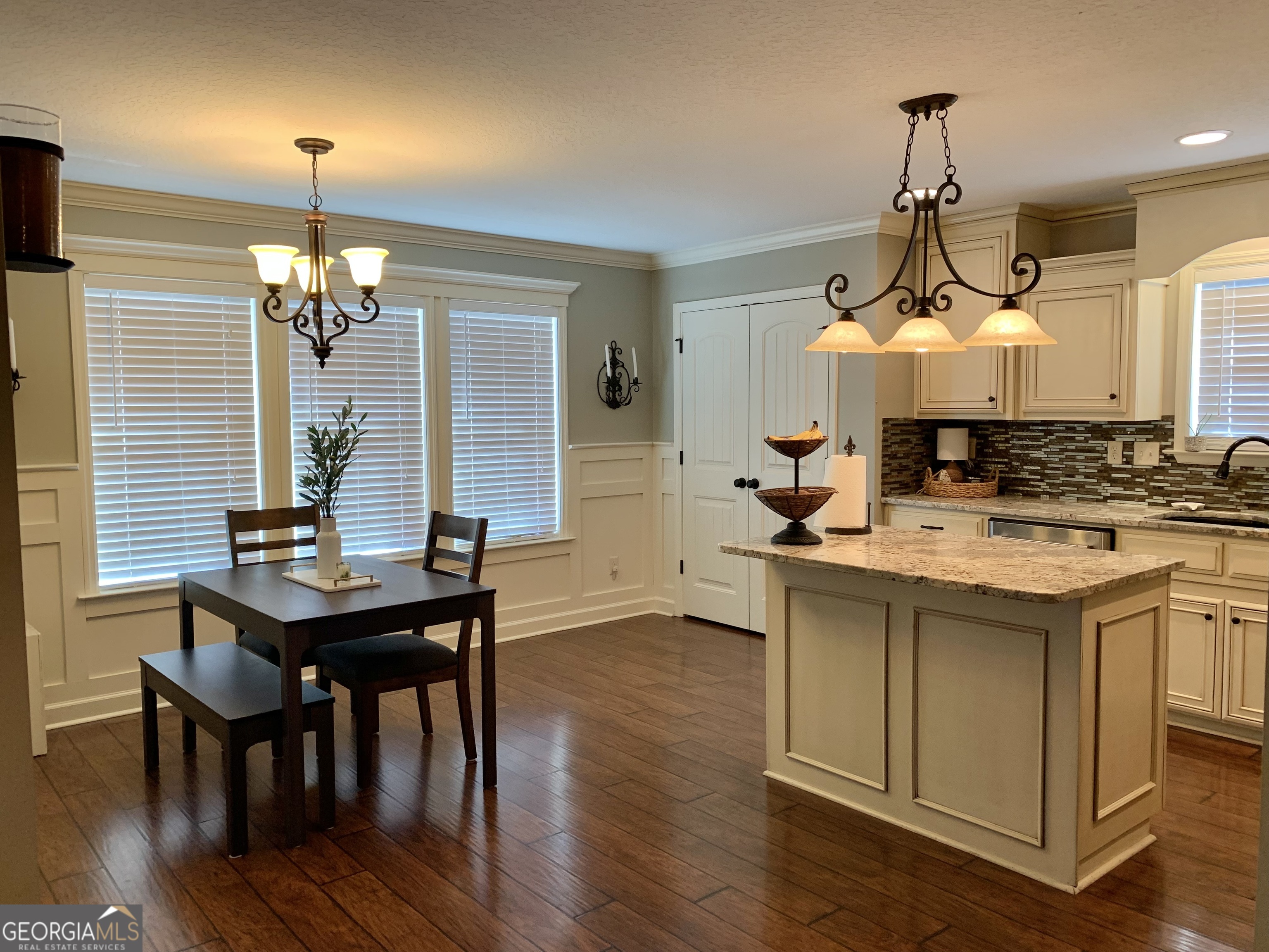 4192 Bright Creek Road Hahira, GA 31632 - Photo 9 of 28 a dining room with wooden floor a chandelier a wooden table and chairs