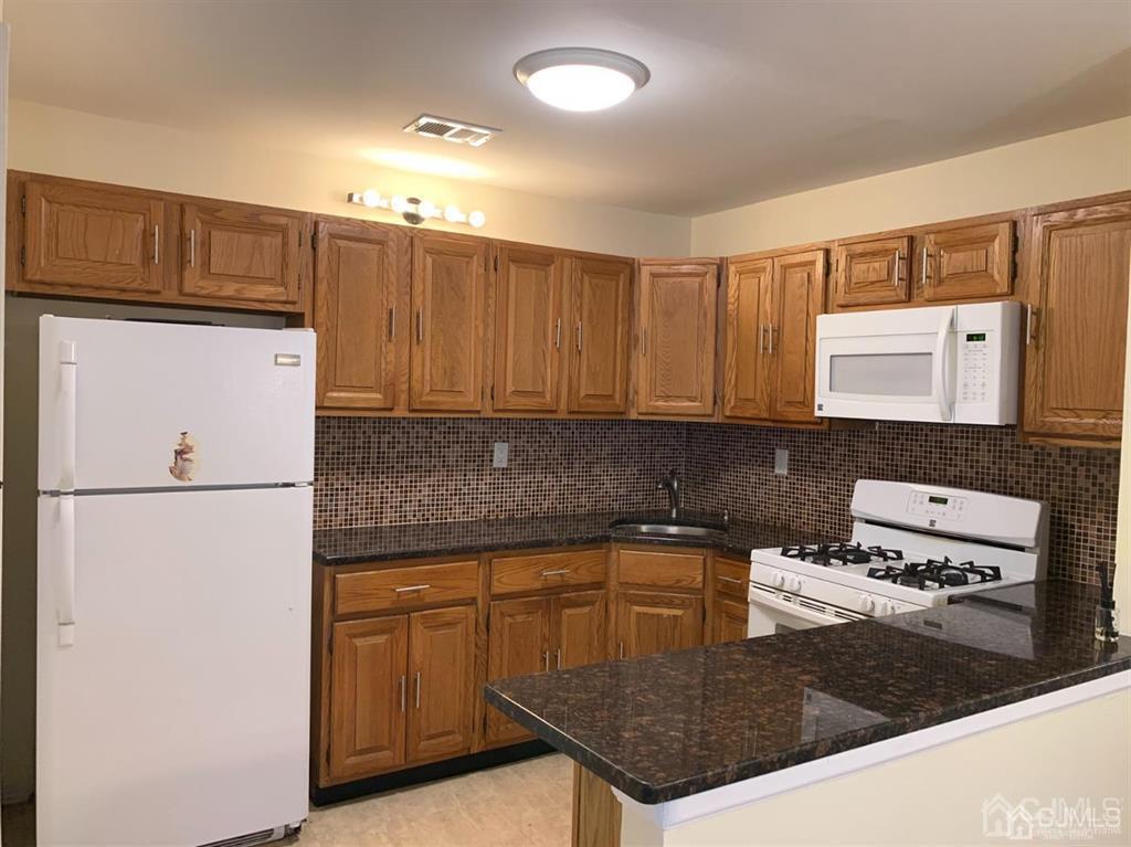 a kitchen with kitchen island a sink a stove and refrigerator