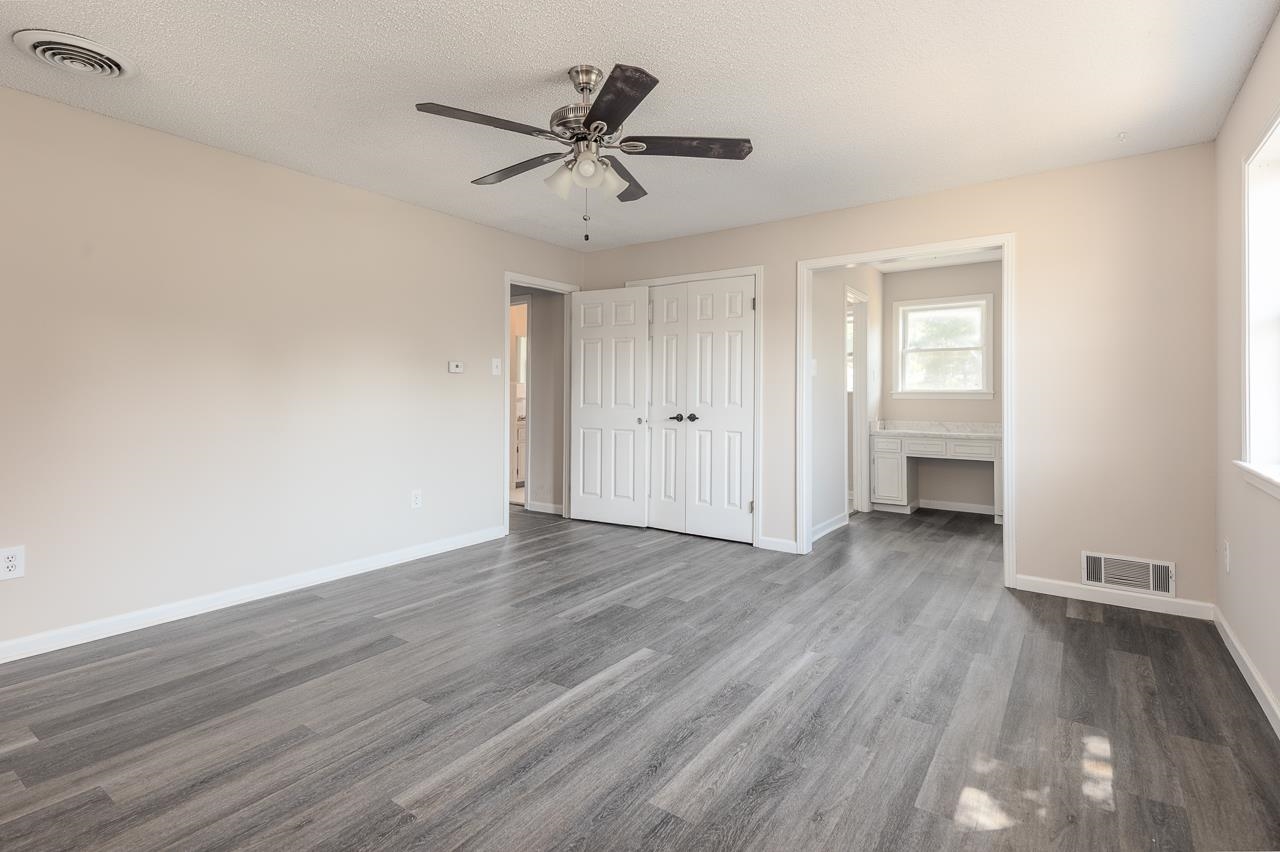 2718 Kate Bond Road Memphis, TN 38133 - Photo 23 of 39 Unfurnished bedroom featuring dark wood-style floors, connected bathroom, a textured ceiling, a ceiling fan, and a closet