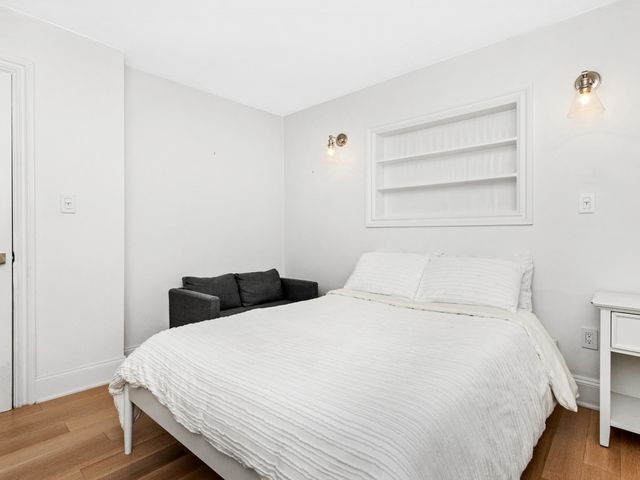 a bedroom with a bed and a wooden floor