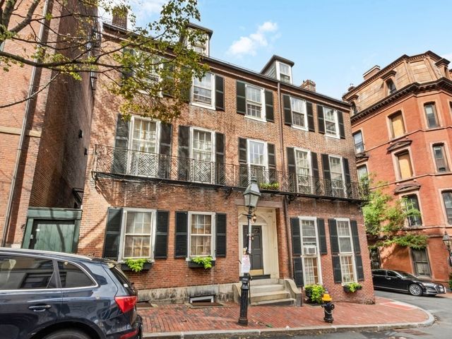a front view of a building and car parked