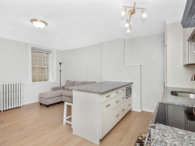 a kitchen with granite countertop a sink stove and cabinets