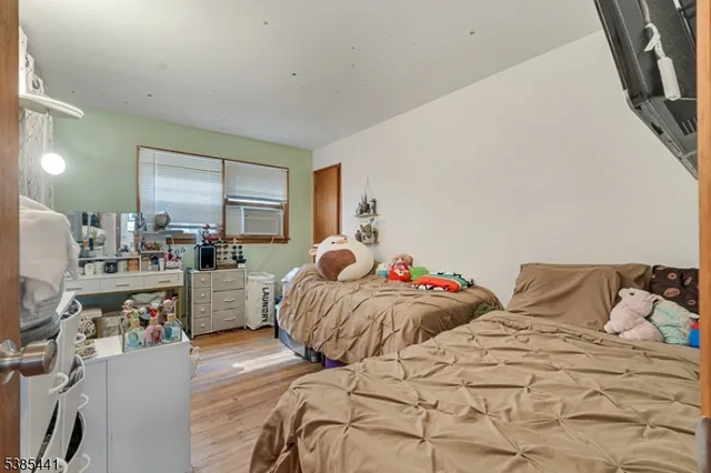a bedroom with two beds and a large mirror next to a window