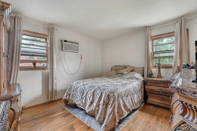 a bedroom with a bed wooden floor and window