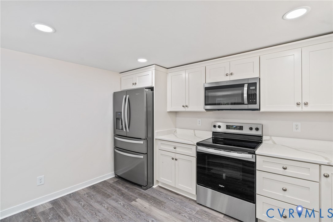 14501 Hopeful Church Road Bumpass, VA 23024 - Photo 12 of 33 a kitchen with white cabinets and stainless steel appliances