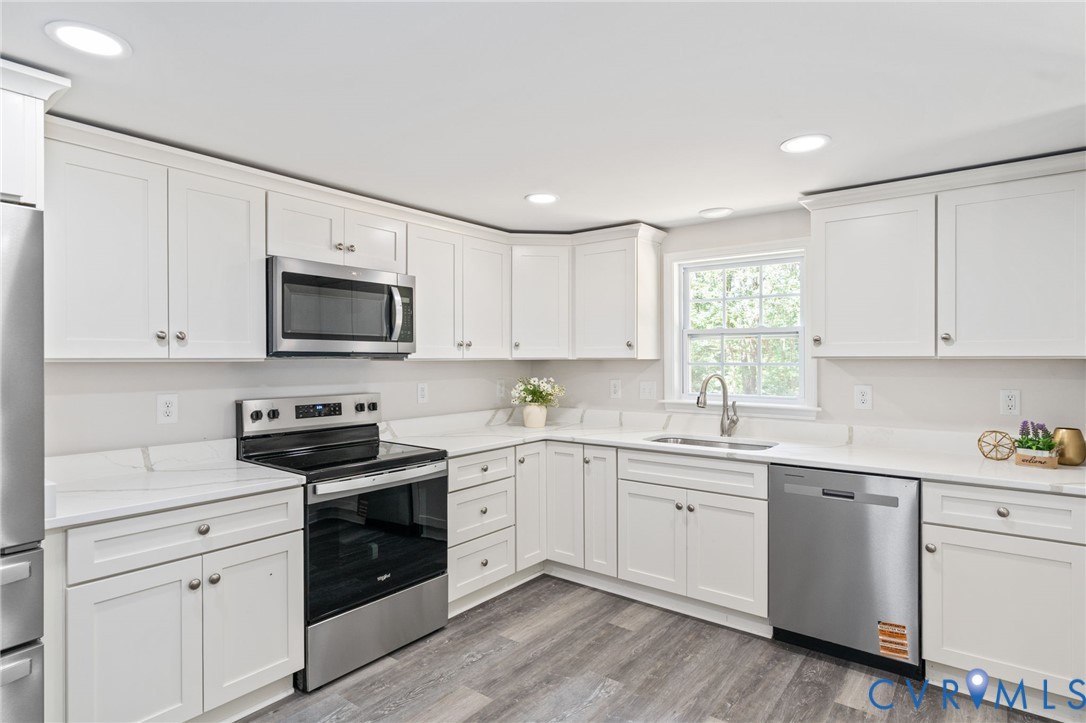 14501 Hopeful Church Road Bumpass, VA 23024 - Photo 16 of 33 a kitchen with white cabinets appliances a sink and a window
