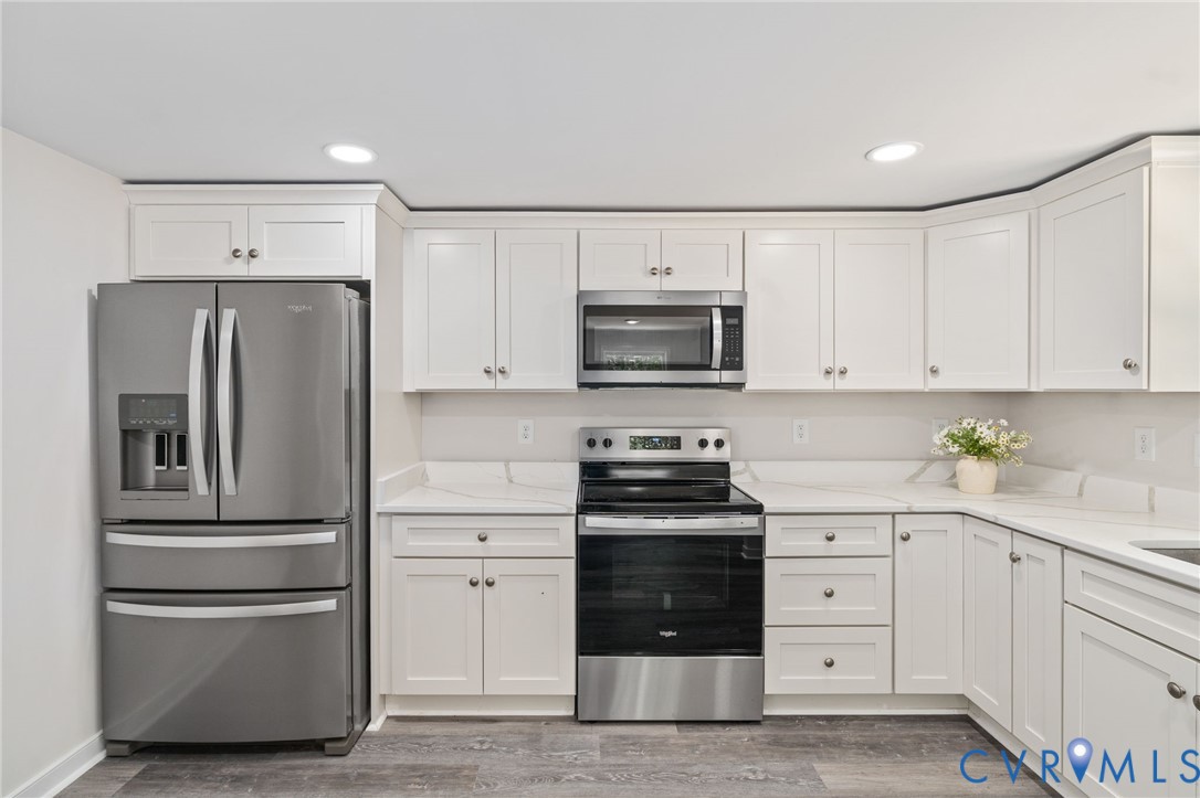 14501 Hopeful Church Road Bumpass, VA 23024 - Photo 17 of 33 a kitchen with white cabinets and stainless steel appliances