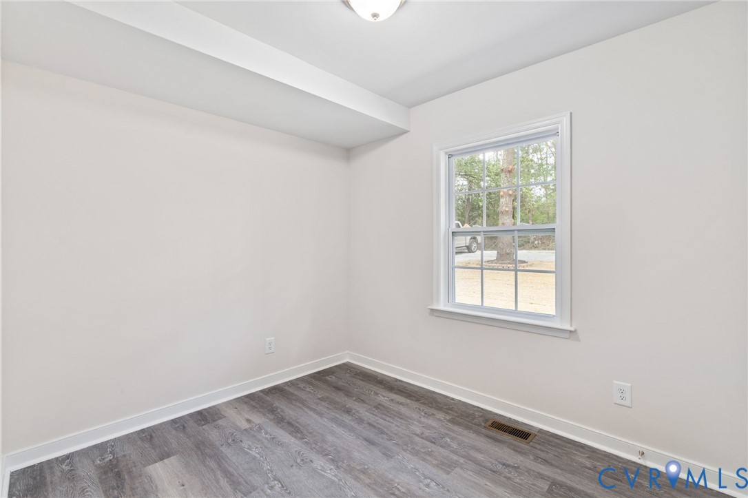 14501 Hopeful Church Road Bumpass, VA 23024 - Photo 21 of 33 an empty room with wooden floor and windows