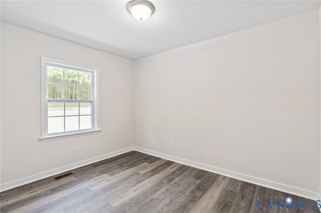 14501 Hopeful Church Road Bumpass, VA 23024 - Photo 23 of 33 an empty room with wooden floor and windows
