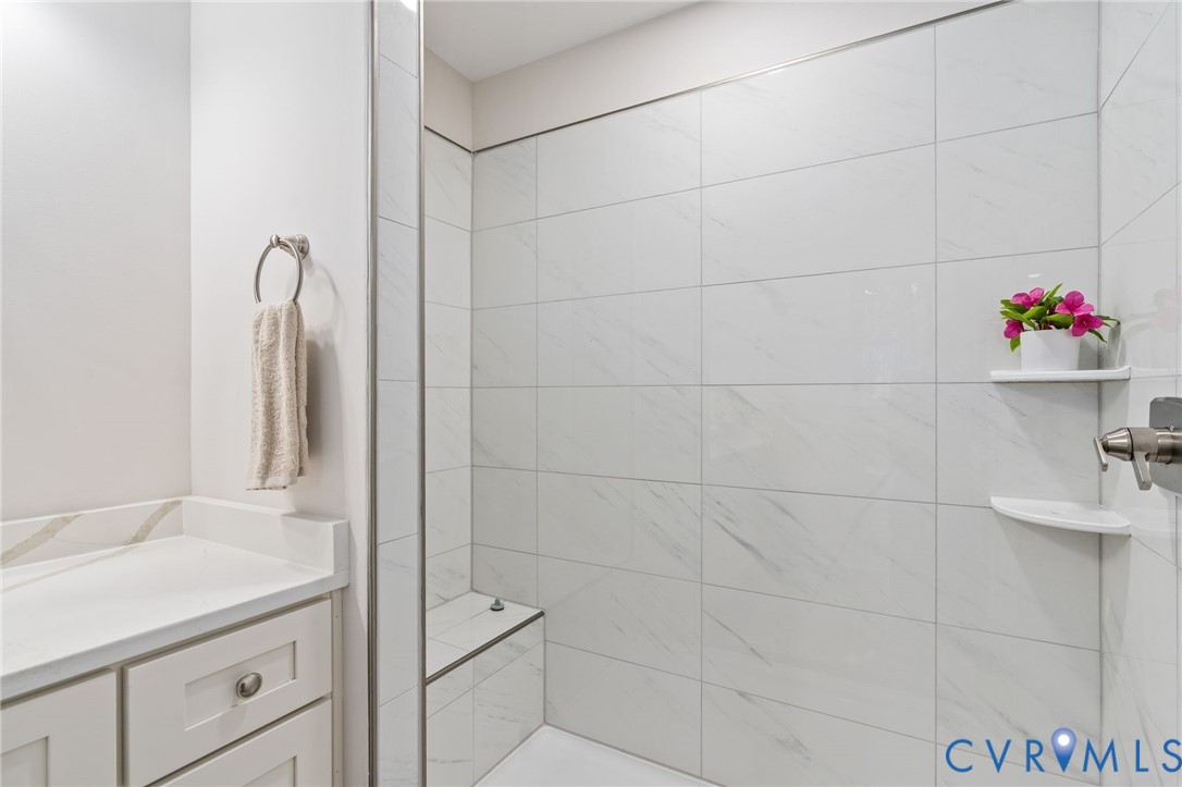 14501 Hopeful Church Road Bumpass, VA 23024 - Photo 29 of 33 a bathroom with a granite countertop shower a sink and a mirror