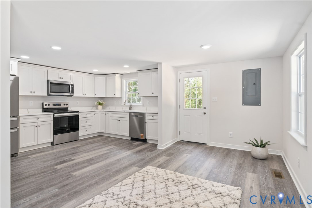 14501 Hopeful Church Road Bumpass, VA 23024 - Photo 9 of 33 a kitchen with wooden floors and white appliances