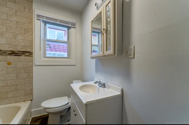 a bathroom with a sink toilet and a mirror