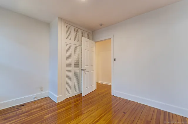 a view of an empty room with wooden floor