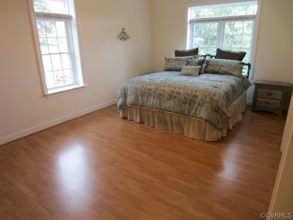 600 Three Chopt Road Manakin-Sabot, VA 23103 - Photo 13 of 24 a spacious bedroom with a bed and wooden floor