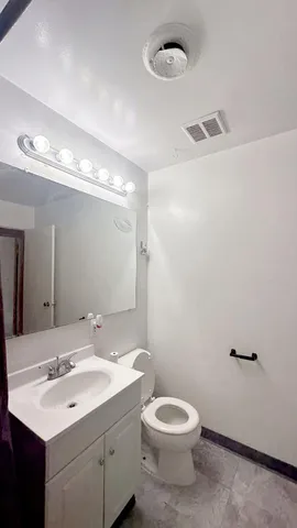 a bathroom with a toilet a sink and mirror