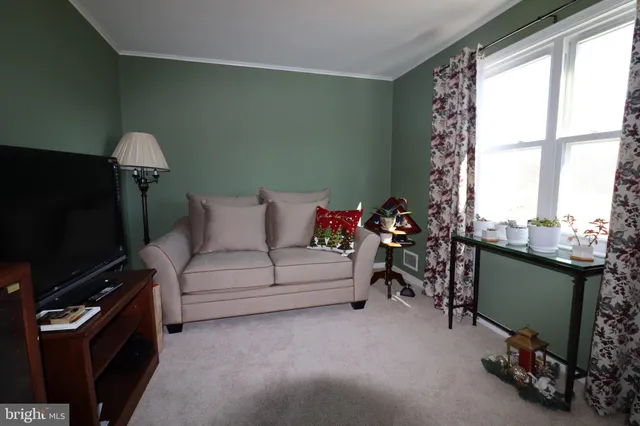 a living room with furniture a flat screen tv and a window