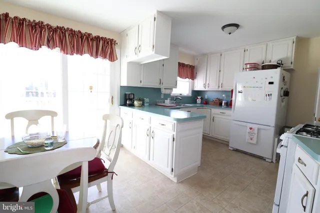 a kitchen with a white cabinets and chairs