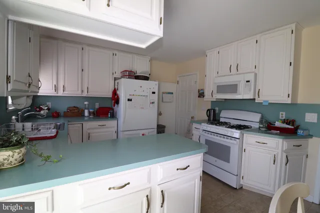 a kitchen with granite countertop a white cabinets and white appliances