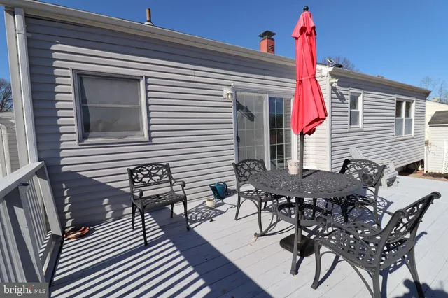 a roof deck with a table and chairs and potted plants