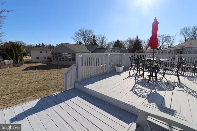 a view of a roof deck with table and chairs couches with wooden floor and fence