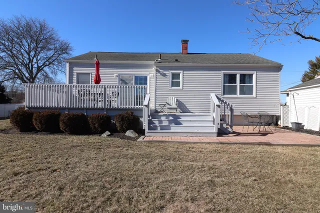 a view of a house with a patio and a yard