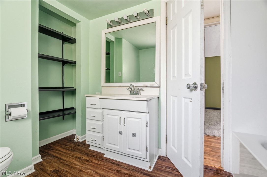 4449 18th Street Northwest Canton, OH 44708 - Photo 19 of 25 Bathroom featuring a white vanity with integrated sink, wood-finish flooring, and wall-mounted mirror