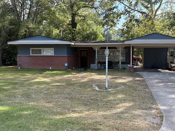 a view of a house with a yard and tree