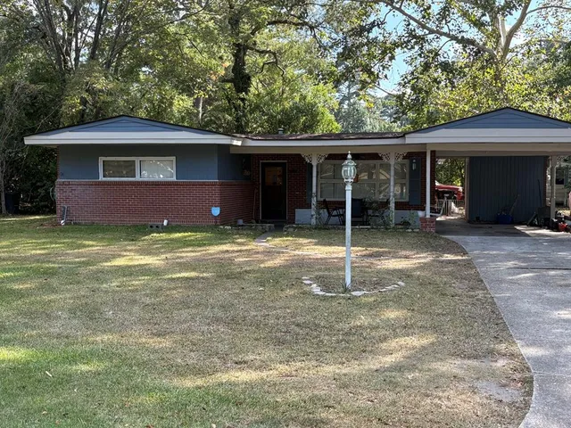a view of a house with a yard and tree