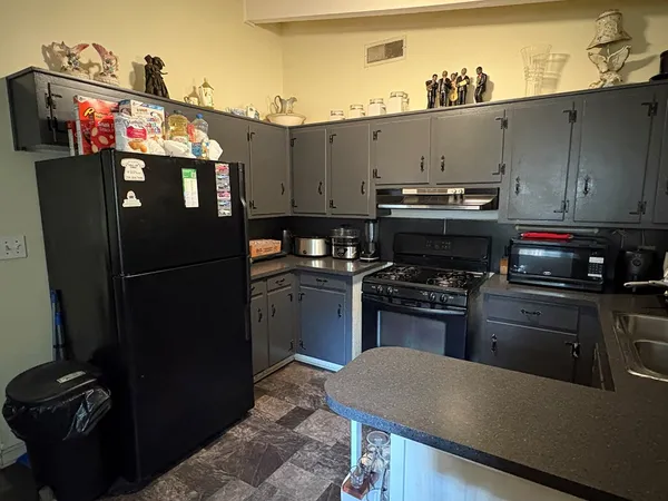 a kitchen with a refrigerator and a stove top oven